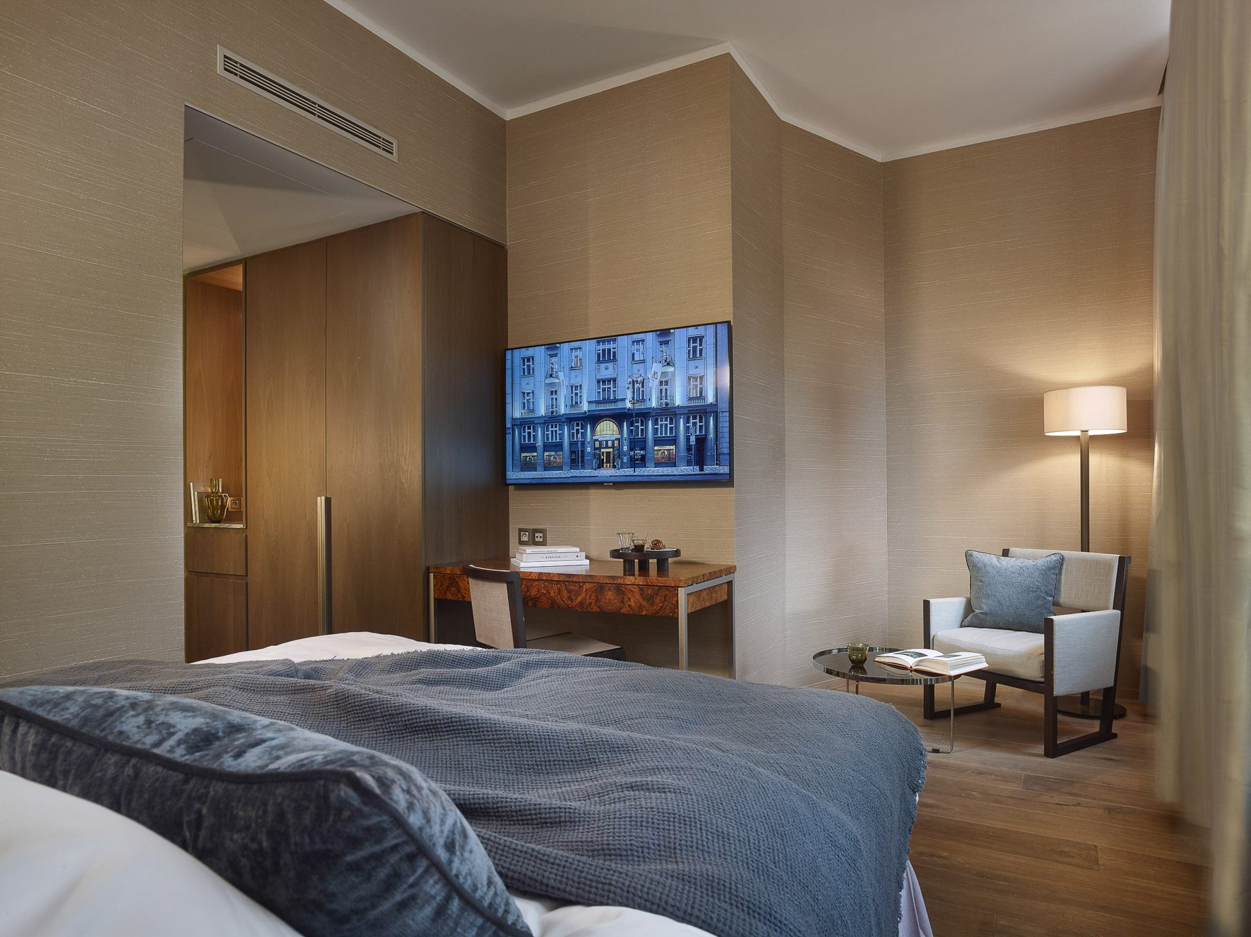 Queen Dom Courtyard bedroom with a bed, desk and armchair.