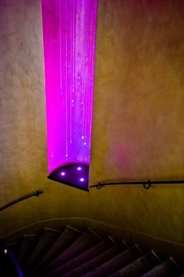 Curving internal stairs with handrails and purple-lit hanging decoration.