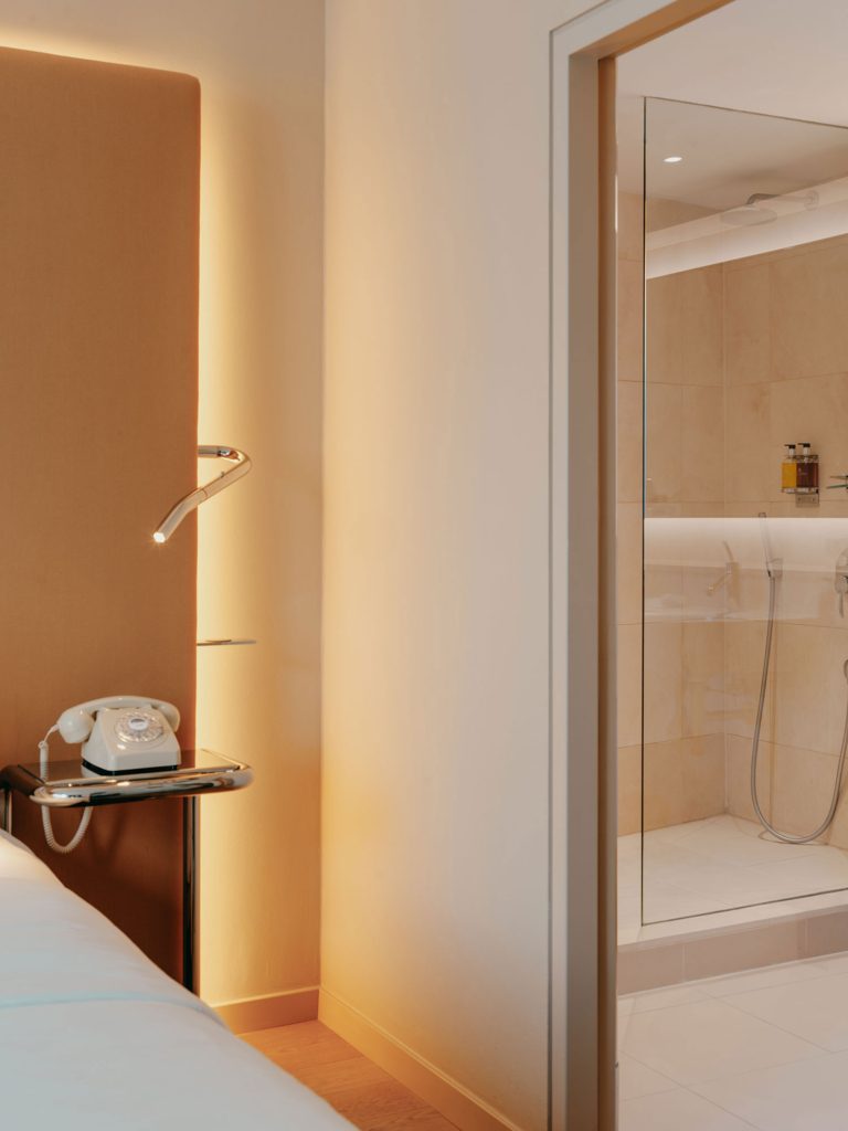 Bedroom doorway opening towards a glass shower enclosure.