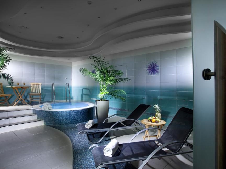 Wellness room with reclining loungers beside a small circular water basin.