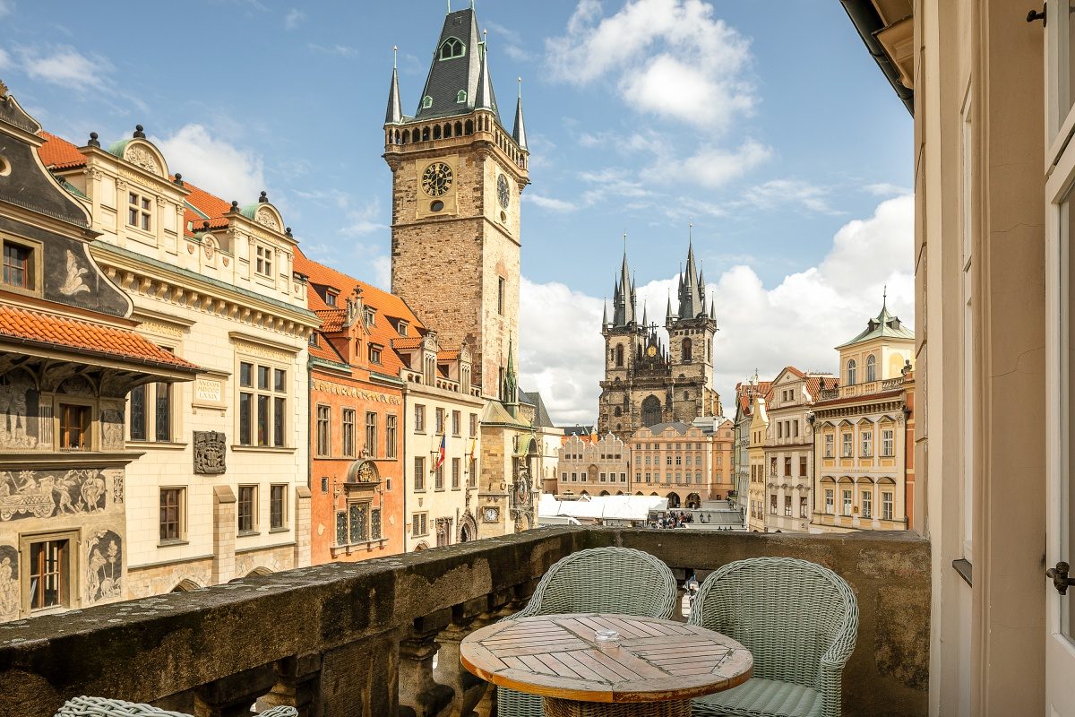 Balcony table and chairs overlooking Old Town Square and the clock tower.