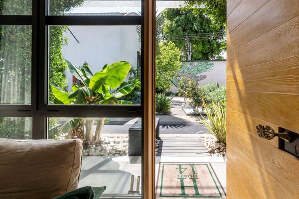 Open bedroom door looking towards a planted garden path.