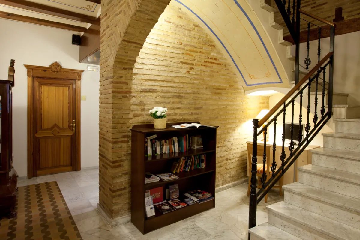 Brick arch, bookcase, patterned floor and marble staircase inside Ad Hoc Monumental.