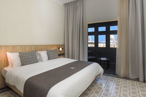 La Falconeria Superior bedroom with enclosed dark timber Maltese balcony.