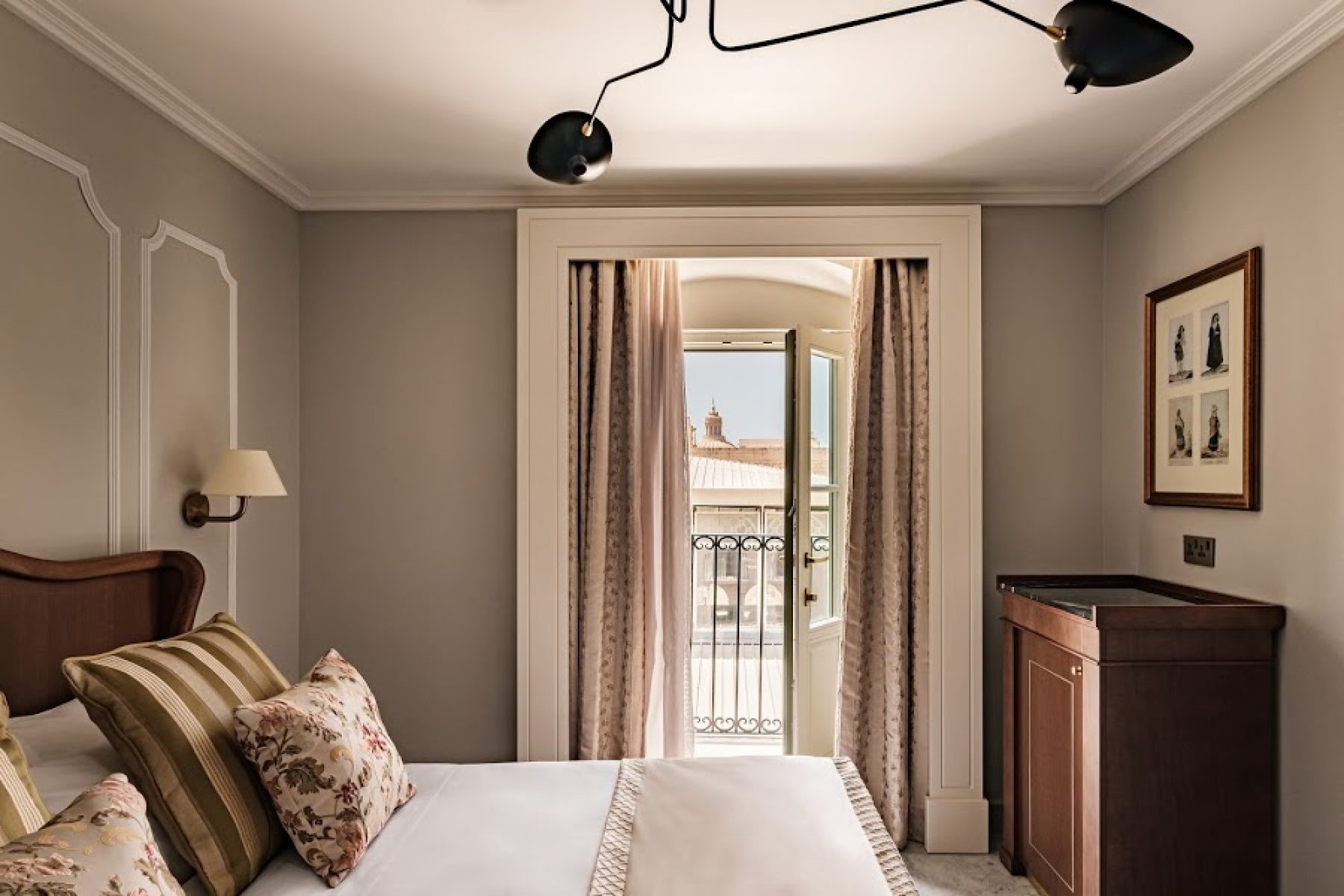 Gomerino bedroom with wooden furniture and French balcony doors.