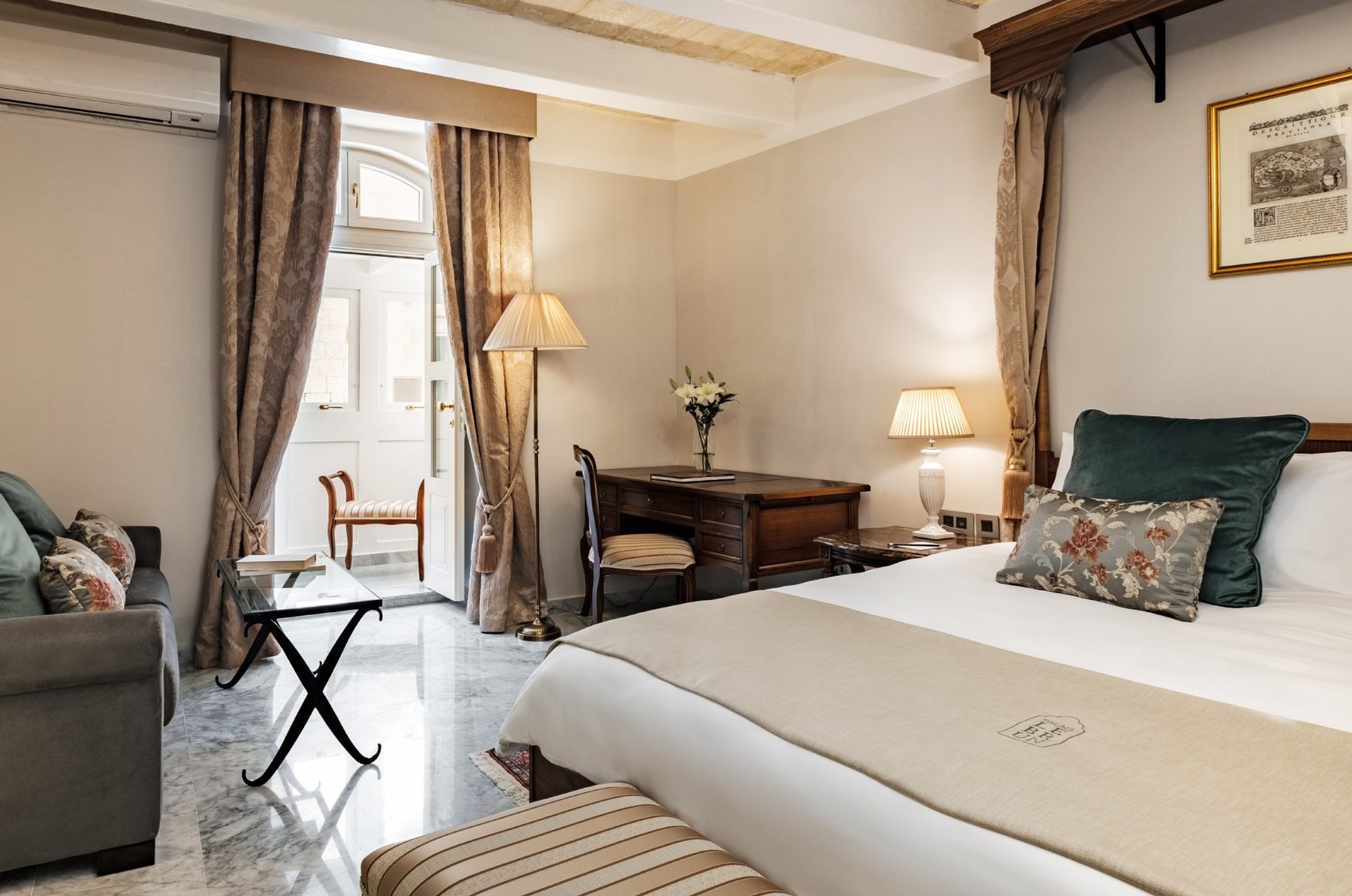 Bedroom and enclosed balcony doorway in a Deluxe Double Room at Palais Le Brun.