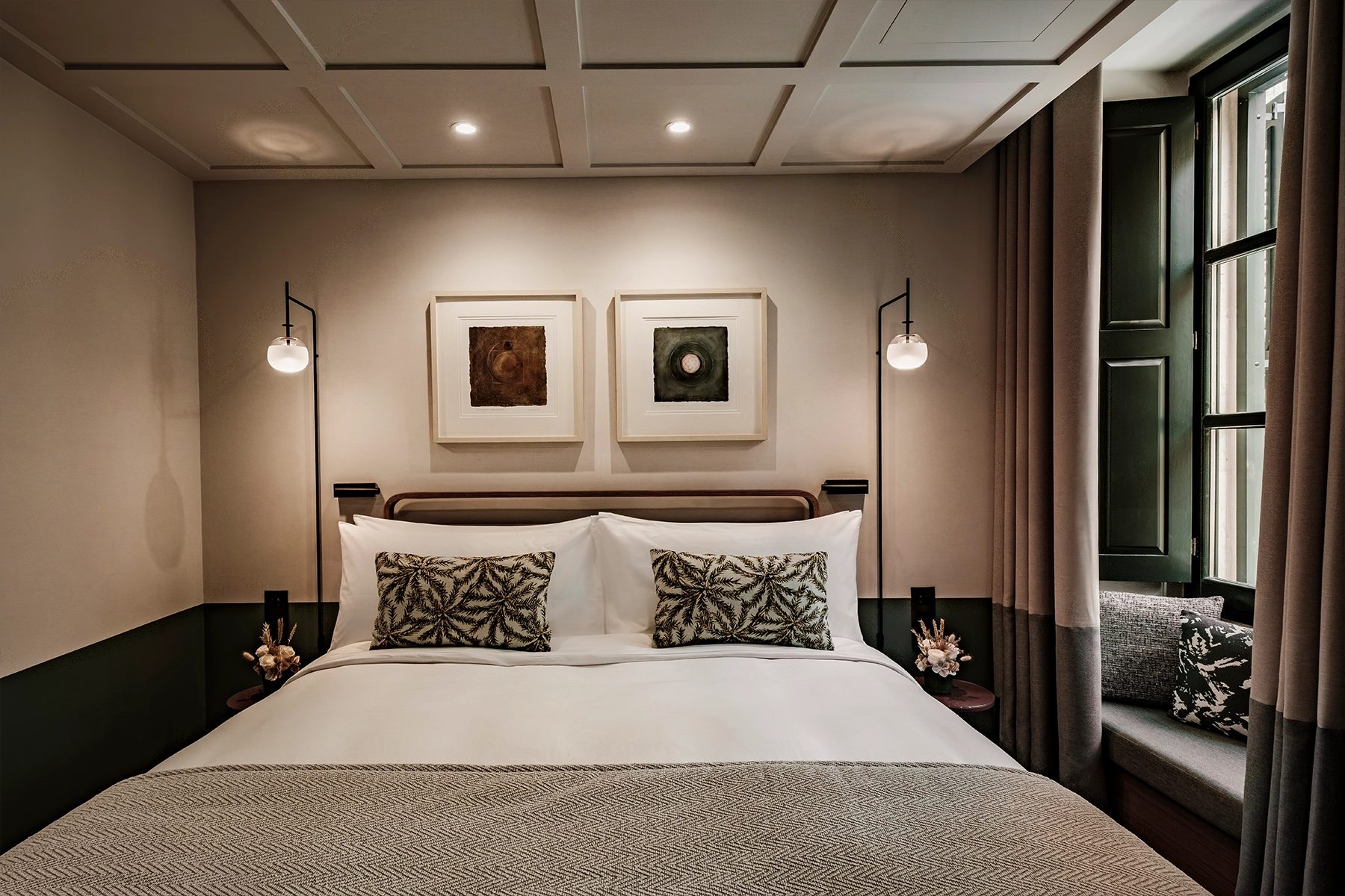 Romègas bedroom with framed artwork and a green enclosed balcony.