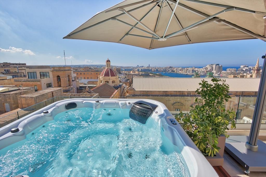 Private terrace hot tub at Palazzo Rosaria’s Executive Suite, with Valletta beyond.