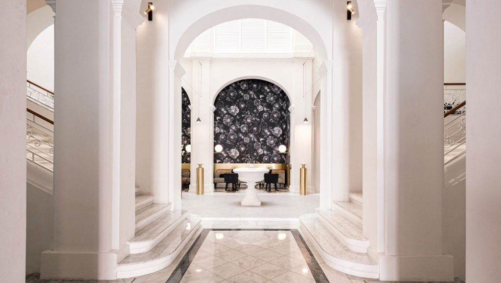 White arches, staircases and a central fountain inside Rosselli.
