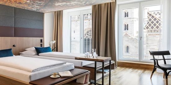 Two beds beside tall windows facing St Stephen’s Cathedral.