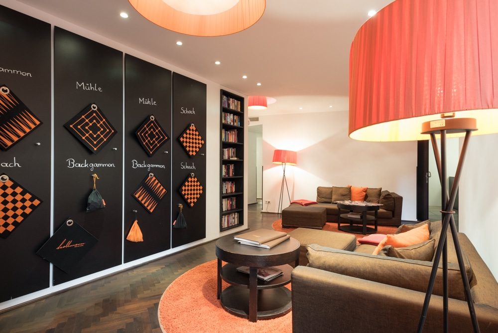 Sofas, red lamps and a wall of board games in the shared lounge.