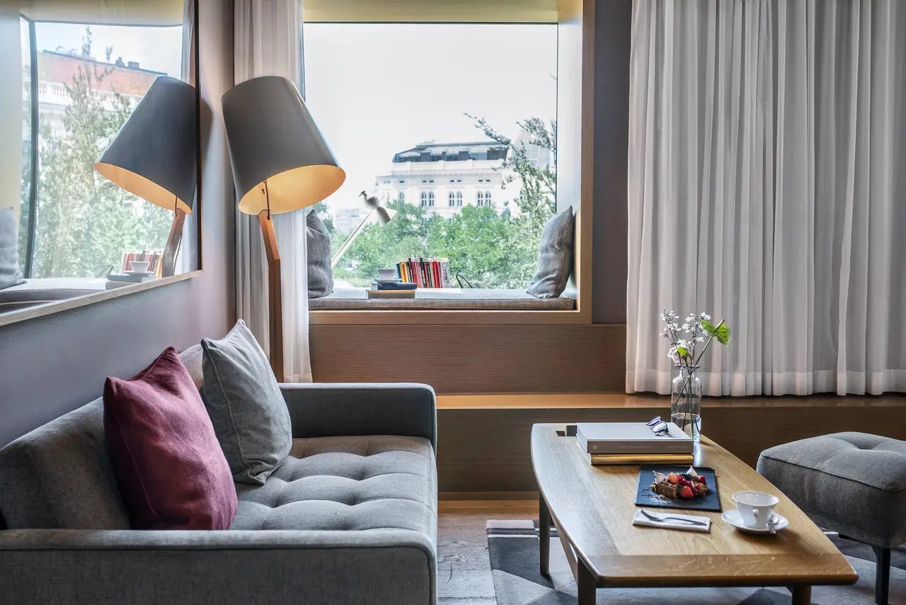 Window seat, sofa and coffee table in a Deluxe Double room at The Guesthouse Vienna.