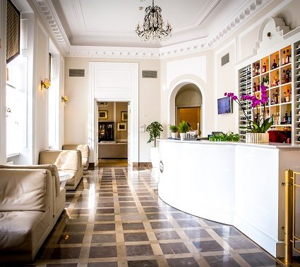 Reception hall with a curved white desk at Hotel Bellotto