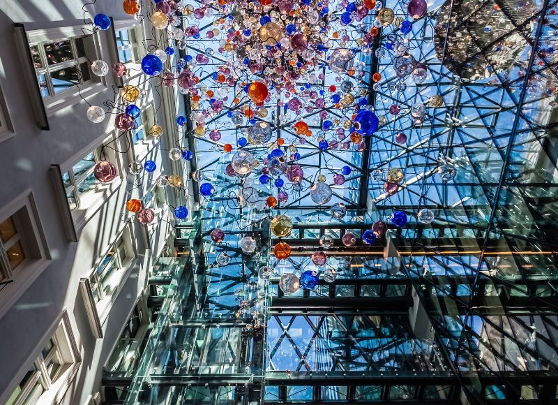 Coloured glass installation beneath Hotel Indigo Warsaw’s glazed atrium roof