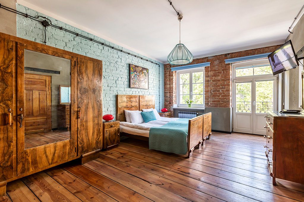Exposed brick and turquoise bedding in Stalowa 52’s Retro room