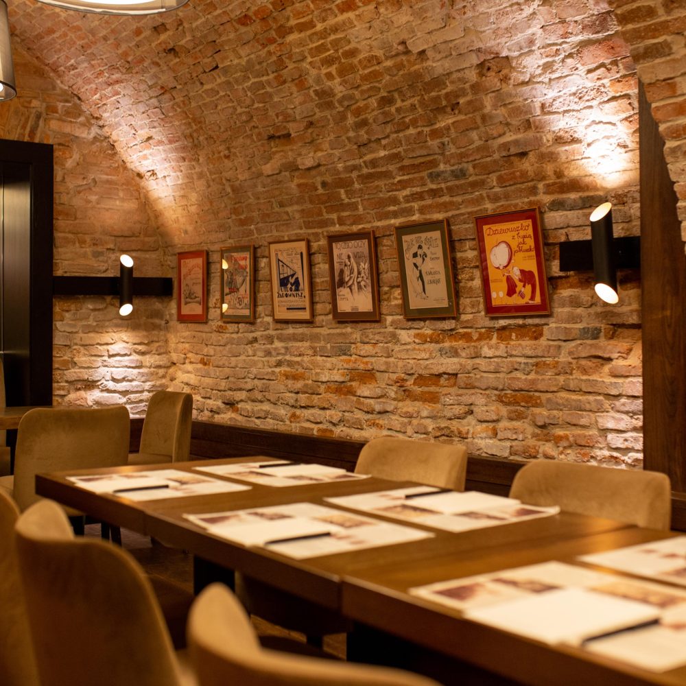 Brick-vaulted dining room with framed posters at Teatro Hotel