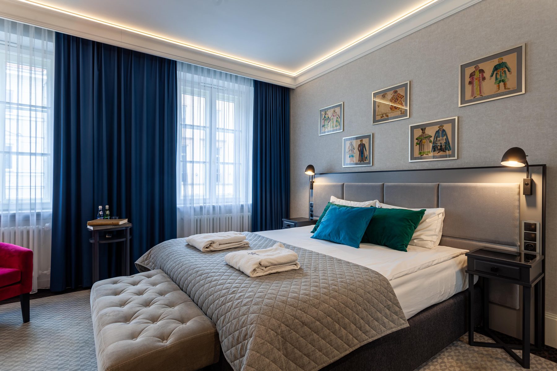Teatro Deluxe bedroom with blue curtains and framed theatre artwork