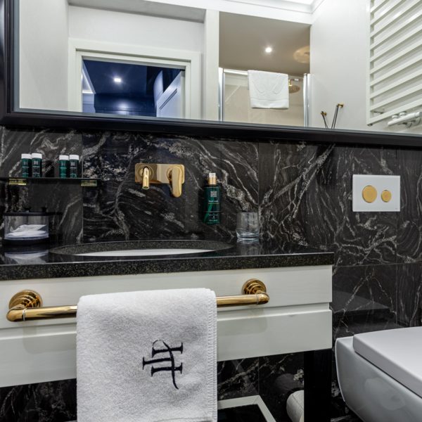 Dark vanity surround and mirror in Teatro’s Deluxe room gallery
