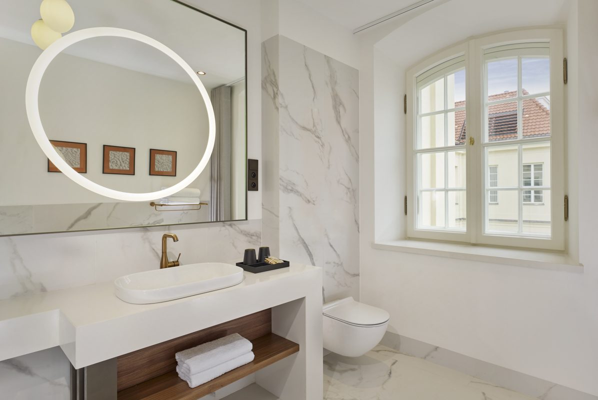 Window and round mirror in a Capriccio bathroom at Hotel Verte