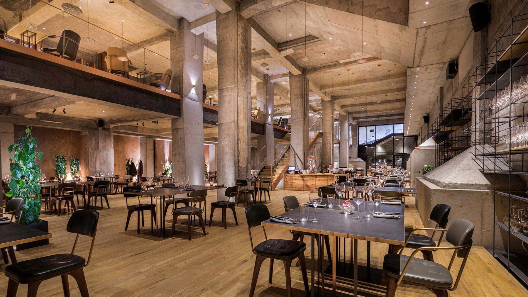 Dining tables beneath exposed concrete beams at Hotel Warszawa