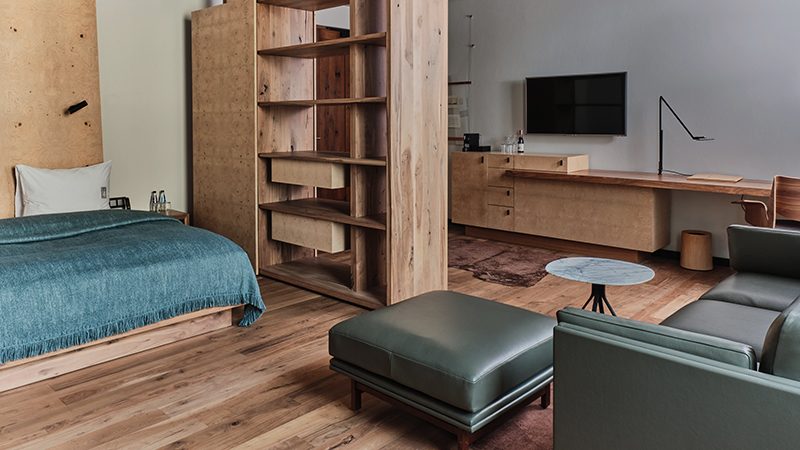 Bed and green seating in a Junior Suite at Hotel Warszawa